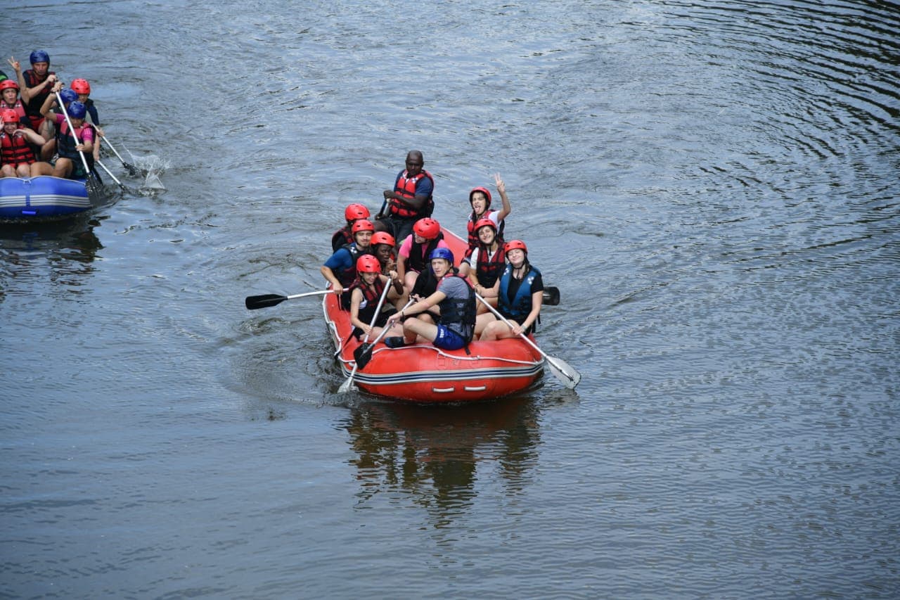 Group paddling hard together through river white water